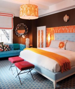 quarto-com-parede-marrom-sofa-e-tapete-azul-e-detalhes-em-laranja